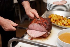 Chef is cutting beefsteak with carving knife