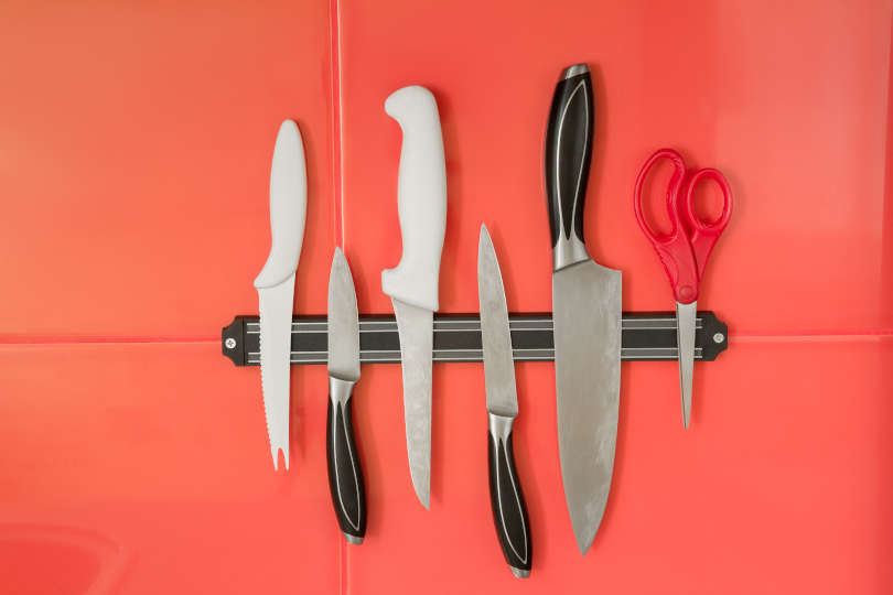 Knife magnet with different knives on the red tile background