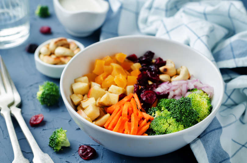 Broccoli carrot cashews apple salad with honey greek yogurt dressing. toning. selective focus