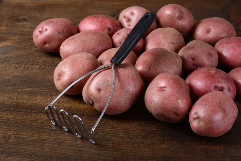 Potato Masher with Potatoes on Board