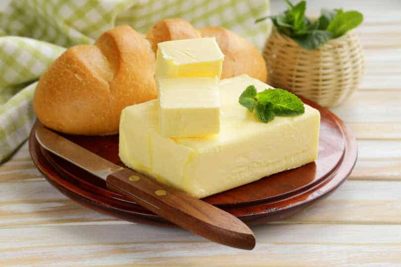 Bread and butter along with butter knife kept on the board