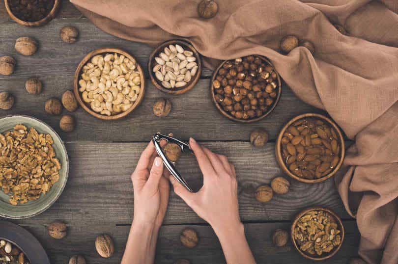 Person cracking walnut with nutcracker