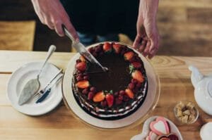 Woman cutting chocolate cake with cake knife