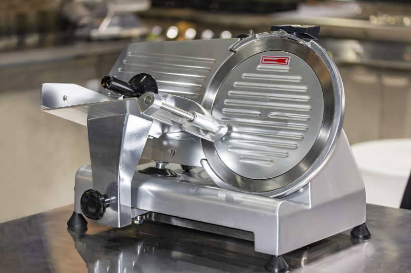 Electric semi automatic frozen meat slicer on the table