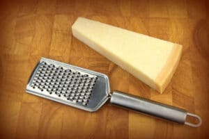 Parmesan cheese and grater on board