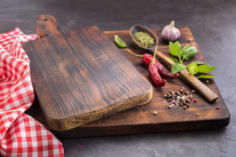 Cutting board and Spices. Hot peppers, Basil, Garlic and dried herbs