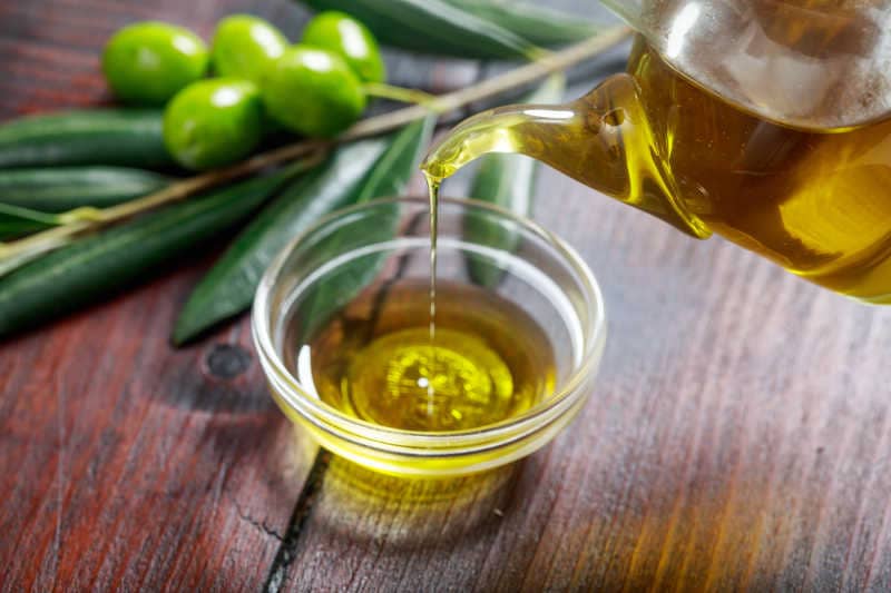 Olive oil and olive twig on a table