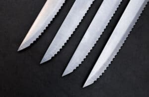 Serrated knives on the dark gray background