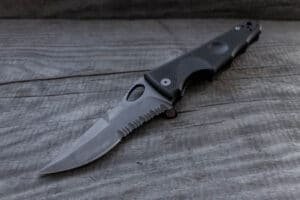 Knife with serrated blade on wooden board