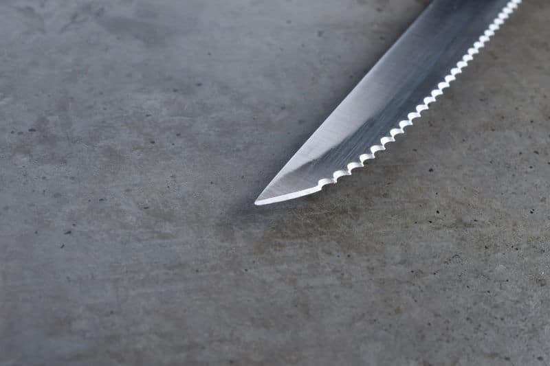 Sharp Serrated Paring Knife on a dark gray concrete table