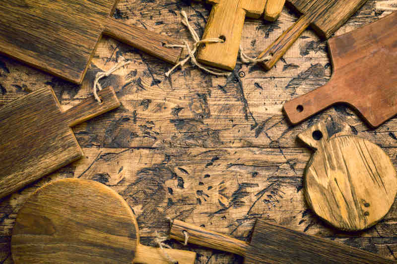 Various wooden cutting boards on wooden kitchen table