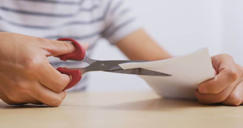 Man cutting paper by scissor