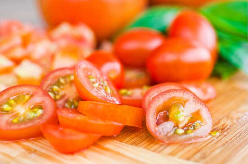 Sliced tomatoes on board