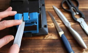 Sharpening a knife on an electric sharpener at home.